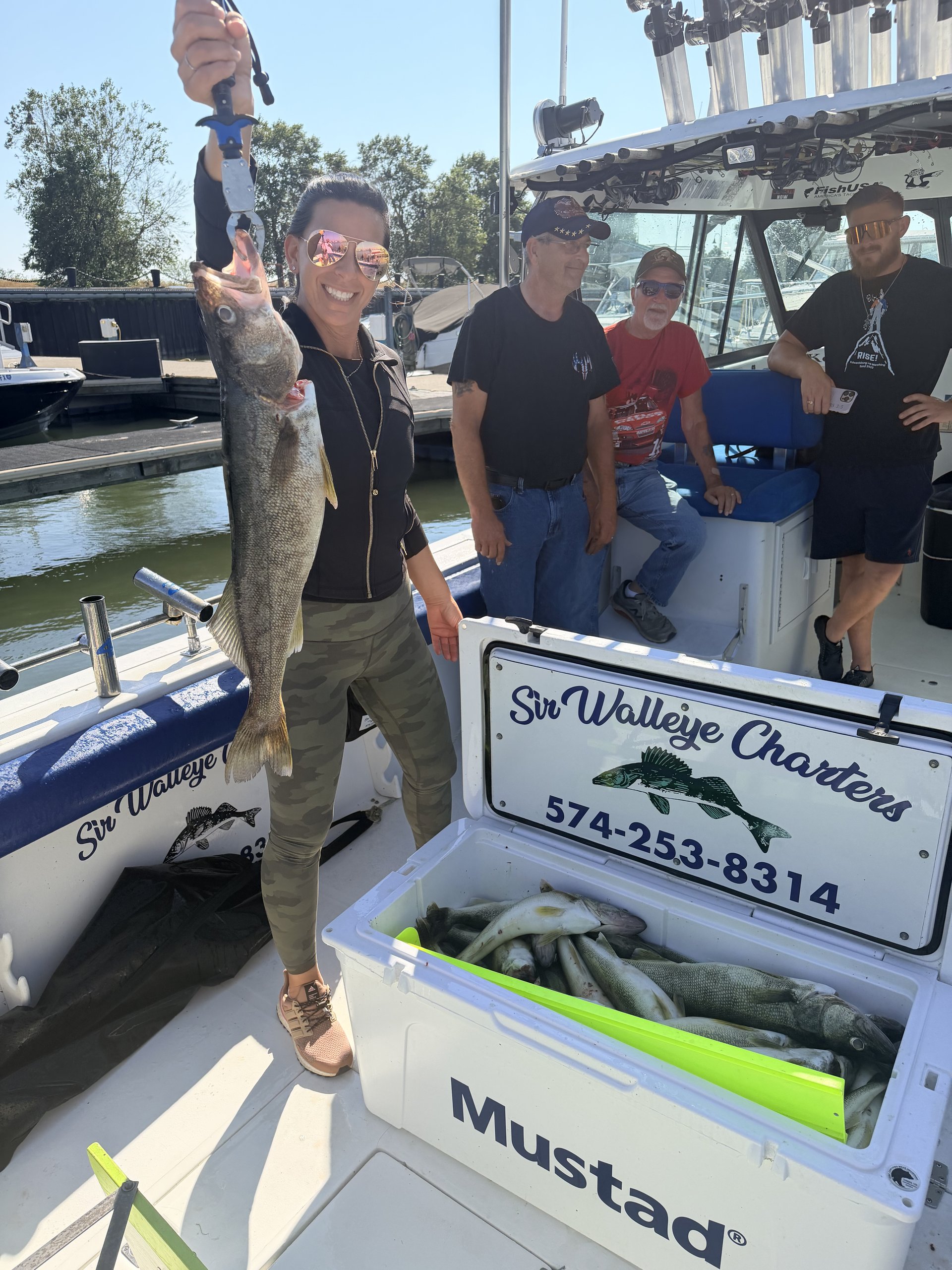 Excited Sir Walleye Charters client hoisting a Lake Erie walleye trophy at the dock