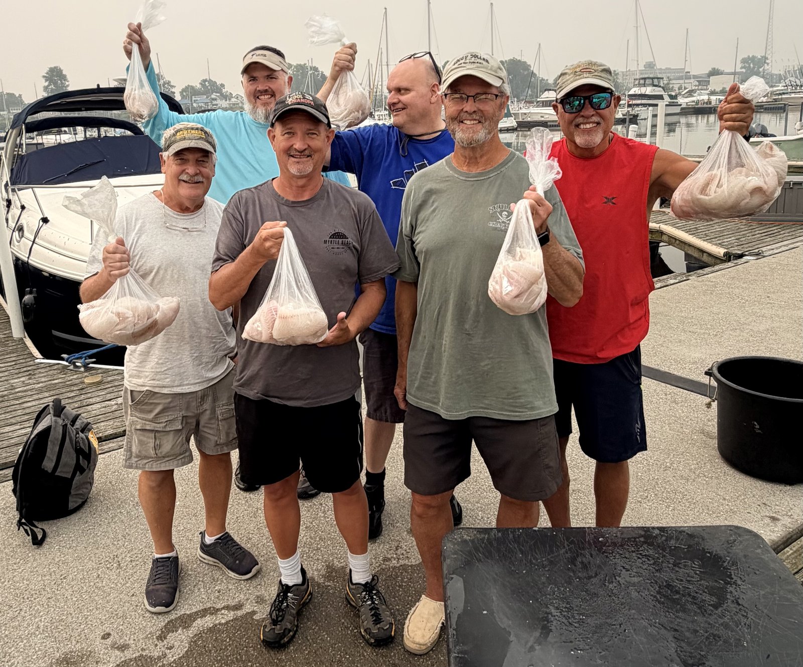 Sir Walleye Charters clients holding bags of Lake Erie walleye fillets at the dock - limits July 2026