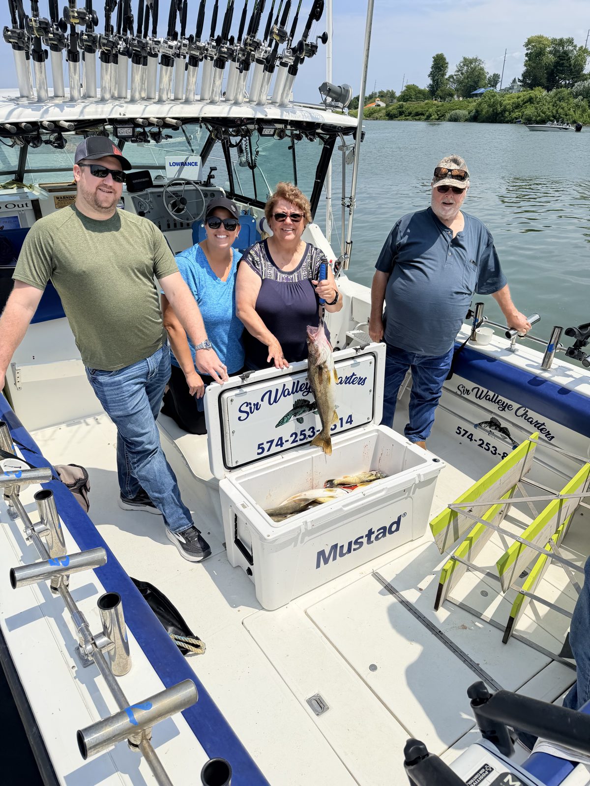 Sir Walleye Charters clients holding Lake Erie walleye over the cooler - July 2026 Central Basin