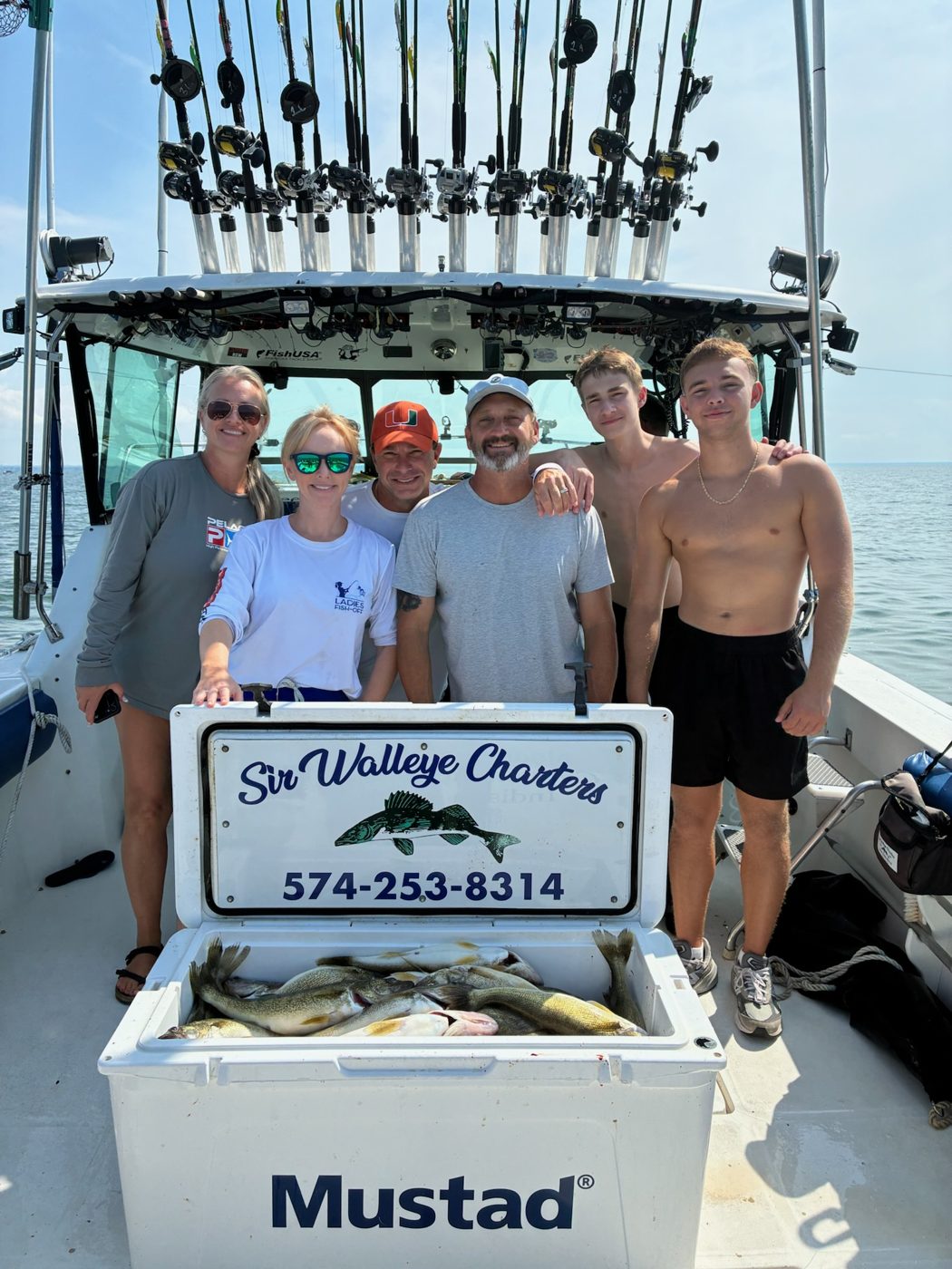 Sir Walleye Charters family group with their limit of Lake Erie walleye in the branded cooler - Central Basin out of Lorain, August 2026