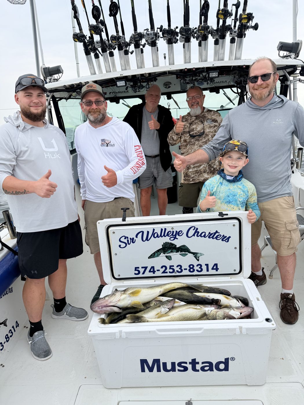 Sir Walleye Charters group with their limit of Central Basin Lake Erie walleye in the branded cooler out of Lorain, Ohio, August 2026