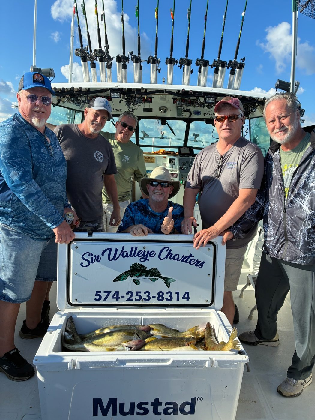 Six happy anglers aboard Sir Walleye Charters behind a Mustad cooler full of Lake Erie walleye out of Lorain, Ohio