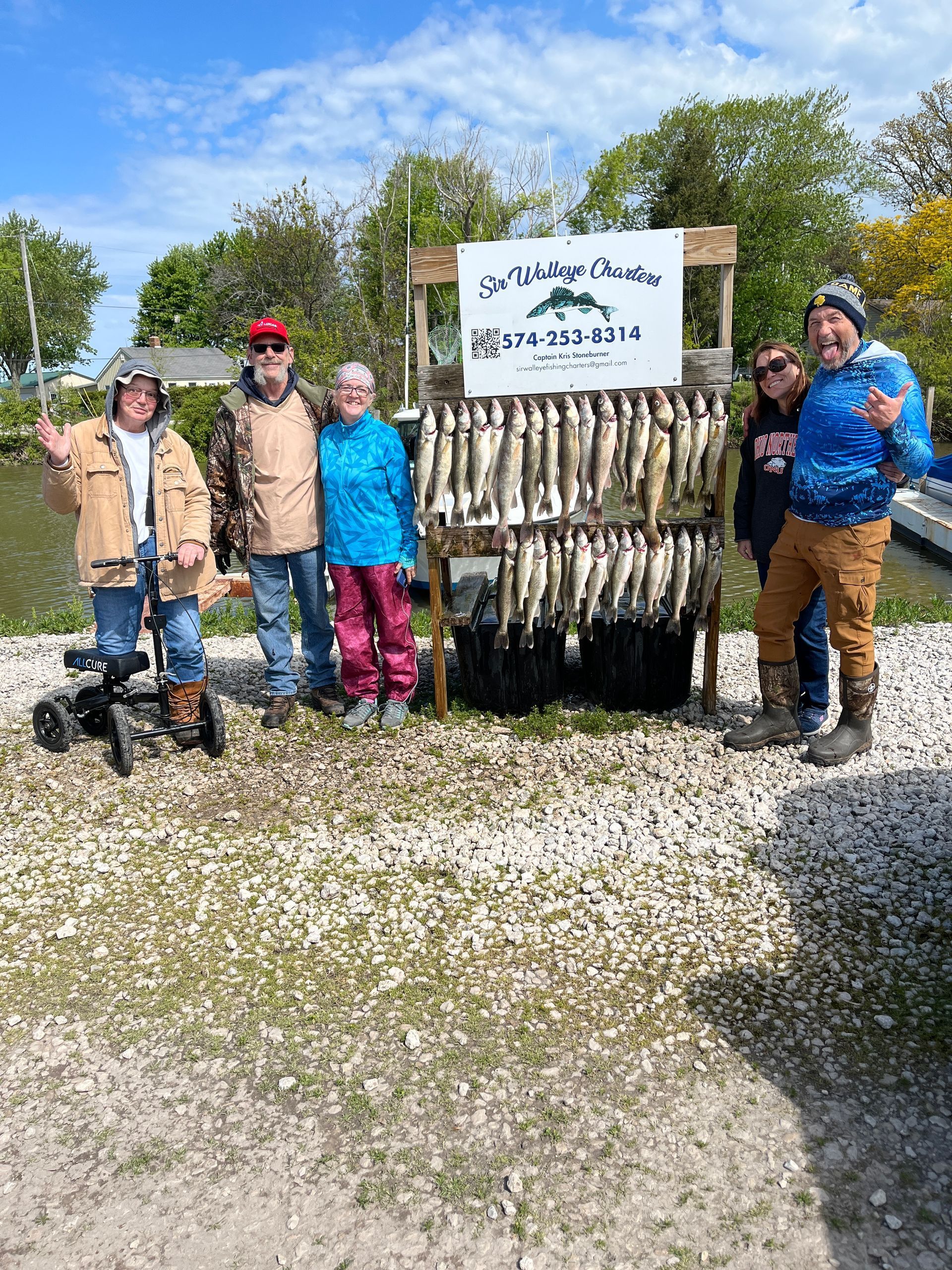 Group of Lake Erie anglers standing next to a fish board with a limit of Lake Erie Walleyes.