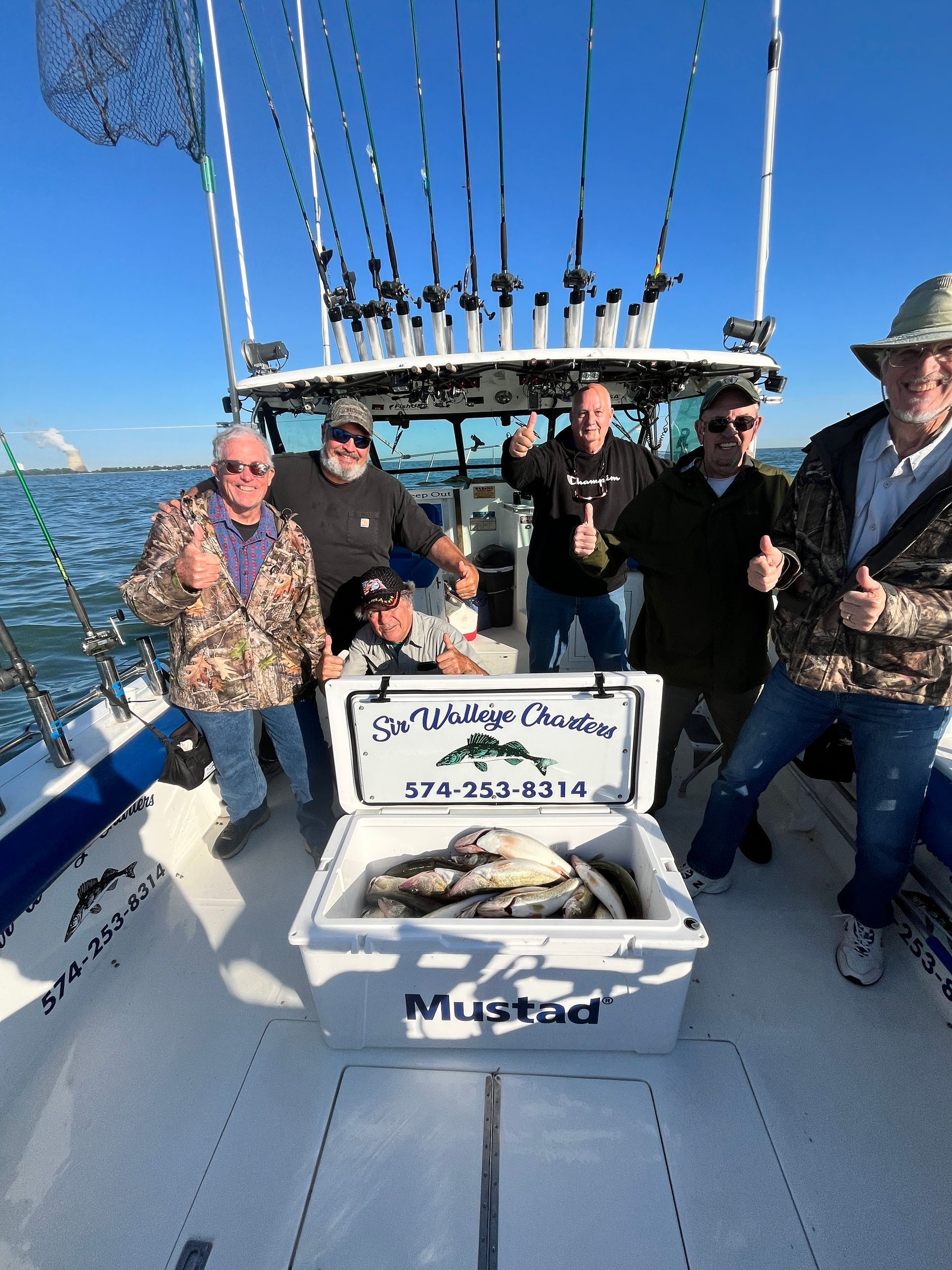 Group of Lake Erie charter fishing clients gathered around a limit catch of walleyes 
